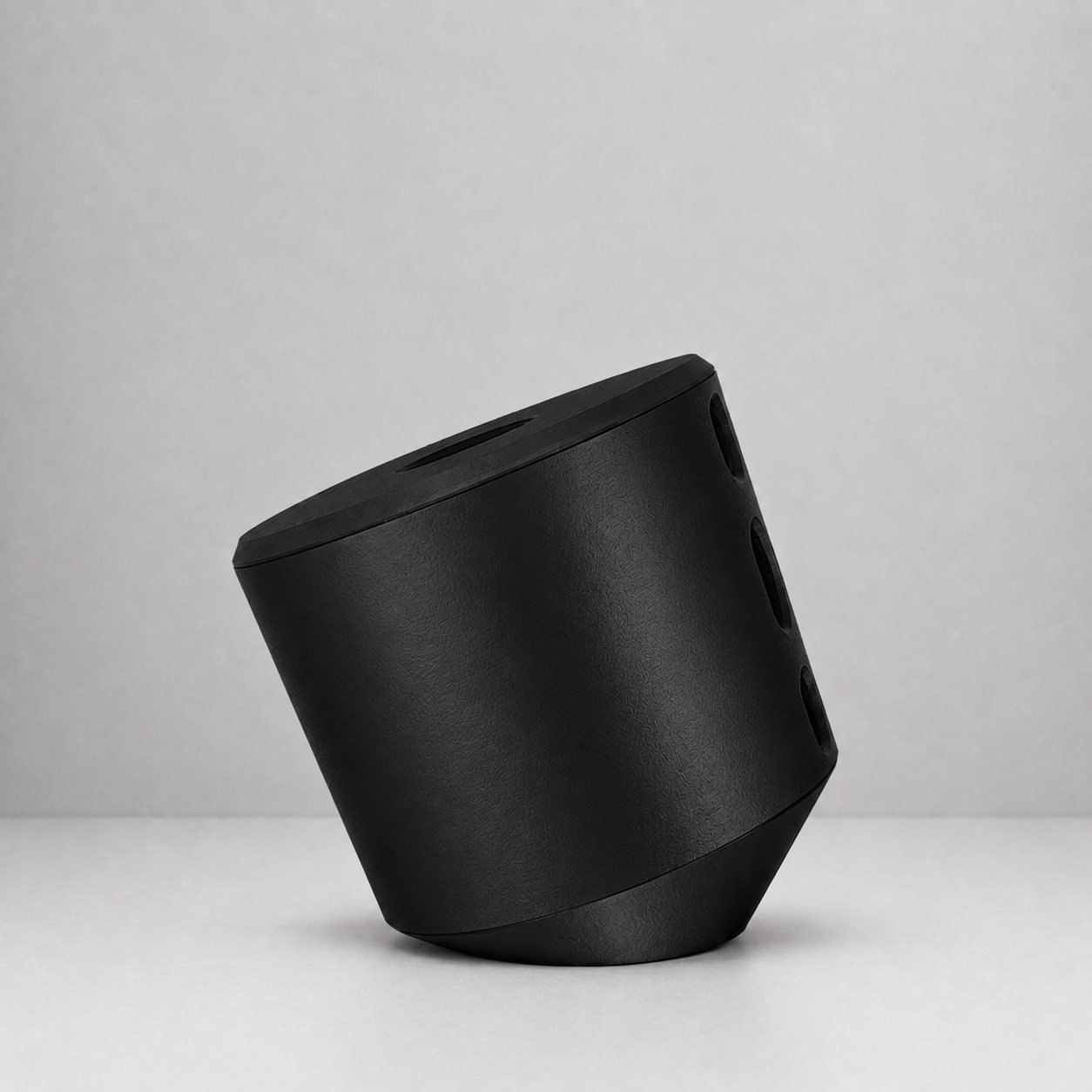 Rollbox Studio Blackout tissue dispenser shown from the side on a light grey surface